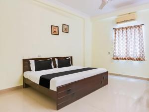 a bedroom with a large bed in a room at Hotel O SS ELITE in Karīmnagar