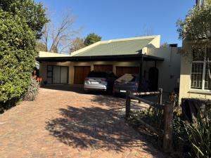 a house with two cars parked in the driveway at The Minimalist Suite in Kempton Park