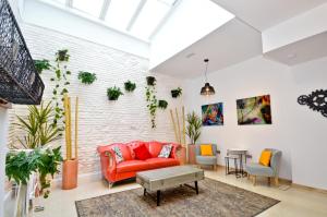 ein Wohnzimmer mit einem roten Sofa und einer Ziegelwand in der Unterkunft The Zentral Arenal Suites in Sevilla