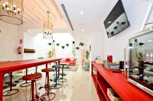 ein Wohnzimmer mit einer roten Bar mit Hockern in der Unterkunft The Zentral Arenal Suites in Sevilla