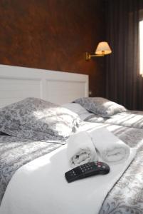 a remote control sitting on top of a bed at Hotel Iguareña in Ezcaray