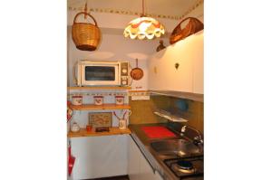 una pequeña cocina con microondas y fregadero en Rustico nel complesso Chapelle, en Sauze dʼOulx