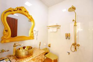 a bathroom with a gold sink and a mirror at Van Don Royal Hotel in Hà Cái +35 photos