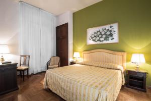 1 dormitorio con cama y pared verde en Hotel Isabella, en Taormina