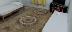 a living room with a bed and a rug at Forteresse Ait-Mezline in Timimoun