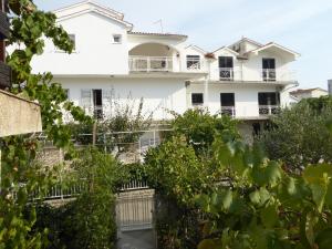 a white building with trees in front of it at Apartments Bojanic in Vodice