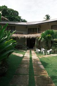 a building with chairs and a grass yard at Easy Does It Guesthouse Siargao in General Luna