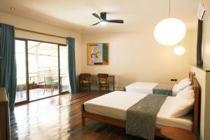 a hotel room with two beds and a balcony at Easy Does It Guesthouse Siargao in General Luna