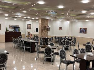 a restaurant with tables and chairs in a room at Sparr Hotel in Amman