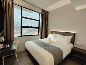 a hotel room with a bed and a window at The Great Hotel Greenhill in Ipoh