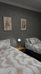 a bedroom with two beds and two pictures on the wall at 42AtSouth in Vryheid