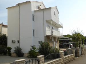 a white building with a bird on the top of it at Apartments Bojanic in Vodice