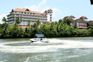 a boat in the water in front of a hotel at The Leela Ashtamudi, A Raviz Hotel in Kollam