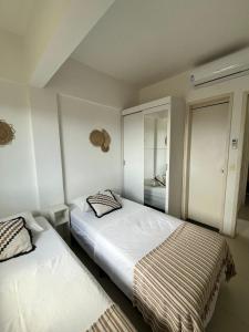 una camera da letto con due letti e uno specchio di Cumbuco Residencial Dunas Beach apt.203 a Cumbuco Altre 24 foto