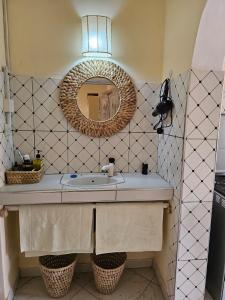 a bathroom with a sink and a mirror at Orange apartment 1 in Watamu +8 photos