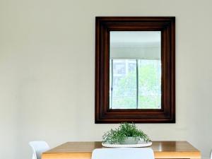 a mirror on a wall next to a table at Epping Station Apartments in Epping