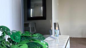 a table with two vases and a mirror and a plant at Epping Station Apartments in Epping +47 photos
