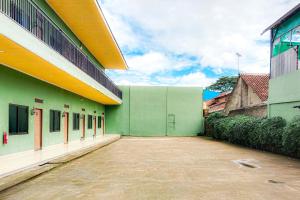 a green and white building with a lot of windows at RedDoorz at Trans Hotel Cilegon in Toyamarta