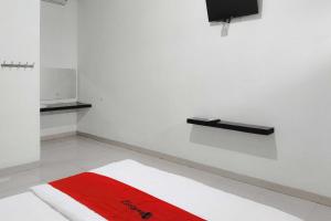 a room with a red and white rug on the floor at RedDoorz at Trans Hotel Cilegon in Toyamarta