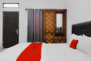 a bedroom with a bed with red pillows on it at RedDoorz at Trans Hotel Cilegon in Toyamarta