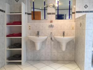 ein Badezimmer mit zwei Waschbecken und zwei Spiegeln in der Unterkunft Family Apartments Eichel in Rust