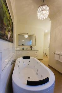 a large white bath tub in a bathroom with a chandelier at Scenic Marysville in Marysville +23 photos