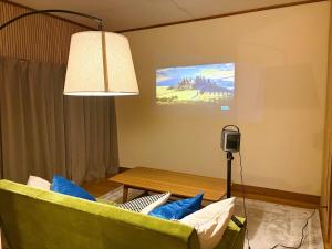 a living room with a green couch and a table at Casa Arita in Zōshuku