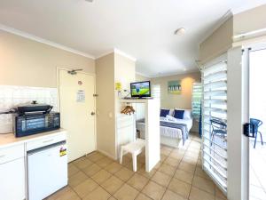 a room with a kitchen and a living room at Mango Sands Villa in Airlie Beach