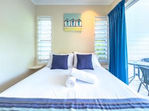 a bedroom with a large bed with blue pillows at Mango Sands Villa in Airlie Beach
