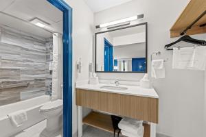 a bathroom with a sink and a toilet and a mirror at Spark by Hilton Kodak in Kodak +30 photos