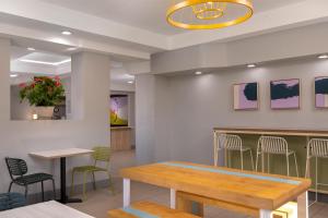 a waiting room with tables and chairs in a restaurant at Spark by Hilton Fishkill in Fishkill