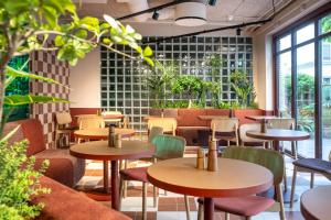 a restaurant with tables and chairs and plants at Hotel Mayfair in Copenhagen