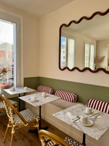 een eetkamer met 2 tafels en een spiegel bij Hotel Saint Louis in Brest