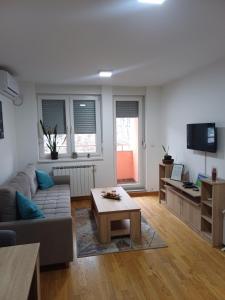 a living room with a couch and a coffee table at Apartman MD in Lukavica