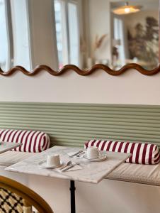 een tafel met twee stoelen en een spiegel aan de muur bij Hotel Saint Louis in Brest