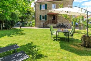 a table and chairs with an umbrella in a yard at Ferienwohnung Apfelbaum Kitzingen in Kitzingen