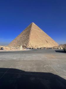 una piramide con molte persone in piedi intorno ad essa di Marhaba Inn Hostel a Il Cairo