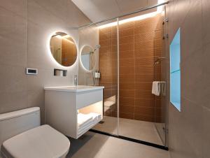 a bathroom with a toilet and a sink and a mirror at Hanpin Homestay in Yuli