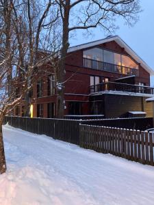 a house in the snow with a fence at Sunset Apartment, rõduga korter uues majas! in Viljandi