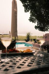 a table with two glasses of wine and a plate of food at Sunrise Cottage in Wilderness