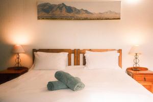 a bedroom with a bed with a green towel on it at Sunrise Cottage in Wilderness