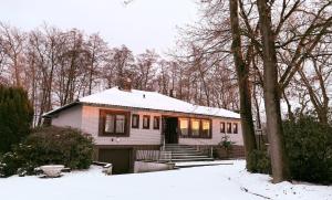 a white house with snow on the roof at HANOSAN Apartments Familienhaus 4 Zimmer 125 m2 in Garbsen