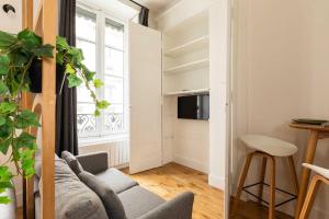 a living room with a couch and a tv at Cosy studio - 2P - Bellecour in Lyon
