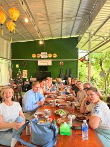 a group of people sitting at a long table at Mekong Delta Homestay 2-Day Tour & Adventure Cycling in Bến Lức