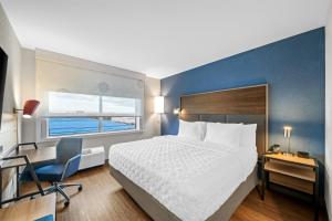 a bedroom with a bed and a desk and a chair at Tru By Hilton Oshawa in Oshawa +59 photos