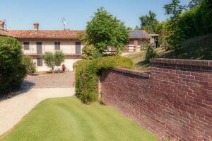 a brick wall with a green lawn in front of a house at StarsBox CasaSilvana in Alba +13 photos