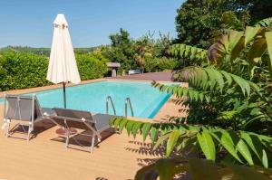 an umbrella and chairs next to a swimming pool at StarsBox CasaSilvana in Alba