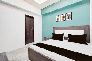 a bedroom with a large bed with a blue wall at Hotel O AB Rooms in Bareilly