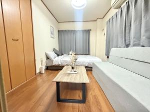 a living room with two beds and a coffee table at Nogata RelaxingHome E2 in Tokyo
