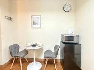 a kitchen with a table and two chairs and a microwave at Nogata RelaxingHome E2 in Tokyo +16 photos